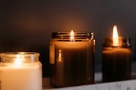 A close-up of burning candles in glass jars creating a warm ambiance.